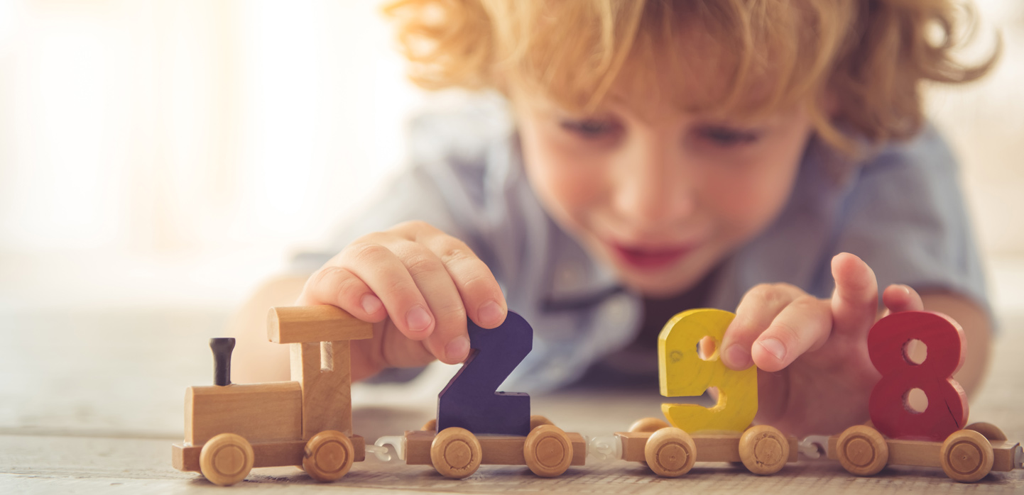 Ein Kind mit Holzspielzeug im Aurora Kindergarten